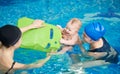 Laughing baby enjoying his first swimming in pool. Little infant playing with floating board. Active lifestyle for child Royalty Free Stock Photo