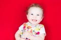 Laughing baby girl in a floral colorful dress