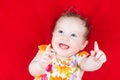 Laughing baby girl playing on a red blanket Royalty Free Stock Photo