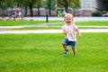 Laughing baby girl running on the green grass Royalty Free Stock Photo