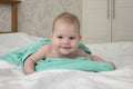 Laughing baby kid lies wrapped in a towel after bathing. joyful positive girl boy naughty look. Baby portrait soft focus Royalty Free Stock Photo