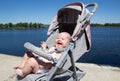 Laughing baby in the stroller at the river Royalty Free Stock Photo