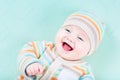 Laughing baby wearing warm knited jacket and hat