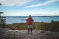Laughing backpacker standing on a rock with Lake Jatkonjarvi behind him in Koli National Park, eastern Finland. The man, aged 24, Royalty Free Stock Photo