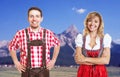 Laughing bavarian man with leather pants and blonde woman with g Royalty Free Stock Photo