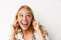 Laughing beautiful girl plugging her ears while posing at camera