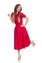 Laughing Beautiful Young Woman In Red Dress And High Heels Is Standing On One Leg Royalty Free Stock Photo