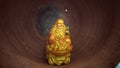 Laughing bhudda statue with beautiful golden color and red background