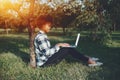 Laughing black girl in park wiht laptop