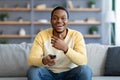 Laughing black guy watching comedy on TV at home Royalty Free Stock Photo