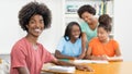Laughing black male student at desk with group of learning african american students Royalty Free Stock Photo