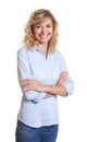 Laughing blond businesswoman with crossed arms