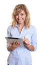 Laughing blond businesswoman with a tablet computer