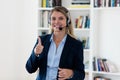 Laughing blond call center female agent with headphones Royalty Free Stock Photo