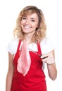 Laughing blond saleswoman showing raw steak