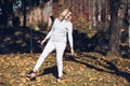 Laughing blond woman, enjoying time outdoor nature, playing day off golden foliage yellow leaves maples. On grass hill Royalty Free Stock Photo