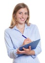 Laughing blonde businesswoman with clipboard
