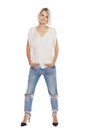 Laughing blonde in jeans and a white tank top. Emotion and joy. Isolated on a white background. Vertical. Full height