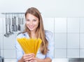 Laughing blonde woman with spaghetti at kitchen