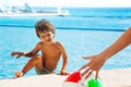 Laughing boy climbs up on boarder of pool to ball Royalty Free Stock Photo