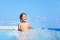Laughing boy plays and splashes water around him Royalty Free Stock Photo