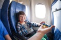 Laughing boy take toy plane, sit in jet airplane Royalty Free Stock Photo