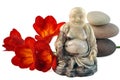 Laughing Buddha, red day-lilies stones. Royalty Free Stock Photo