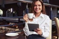 Laughing business woman reading latest news on tablet