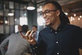 Laughing businessman talking on speakerphone in an office Royalty Free Stock Photo