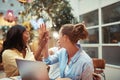 Laughing businesswomen high fiving together in an office lounge