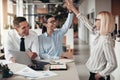 Laughing businesswomen high fiving together during an office mee