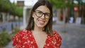 Laughing, carefree hispanic woman with beautiful smile and glasses, confidently posing on tokyo city\'s modern street, exuding a Royalty Free Stock Photo