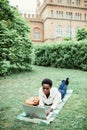 Calm to work outdoors. Young afro american student lying on grass taking notes on campus at college Royalty Free Stock Photo