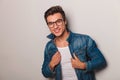 Laughing casual young man holdig jeans jacket`s collar Royalty Free Stock Photo
