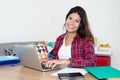 Laughing caucasian female student with laptop