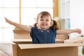 Laughing child girl sitting inside cardboard boxe in her new home Royalty Free Stock Photo