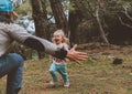 Laughing child running to father family walking together in forest Royalty Free Stock Photo