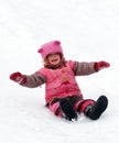 A laughing child sliding in the snow