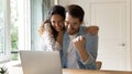 Laughing couple embracing by computer winning at sports betting Royalty Free Stock Photo