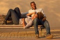 Laughing couple sitting on park bench outside Royalty Free Stock Photo