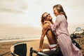 laughing couple standing near scooter on beach Royalty Free Stock Photo