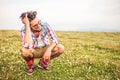 Laughing crouched man passing his hand through his hair Royalty Free Stock Photo