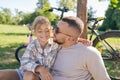 Laughing father and his daughter having fun together at the green park, relax and have fun together after cycling Royalty Free Stock Photo