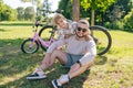 Laughing father and his daughter having fun together at the green park, relax and have fun together after cycling Royalty Free Stock Photo