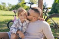 Laughing father and his daughter having fun together at the green park, relax and have fun together after cycling Royalty Free Stock Photo