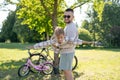 Laughing father and his daughter having fun together at the green park, relax and have fun together after cycling Royalty Free Stock Photo