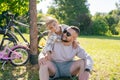 Laughing father and his daughter having fun together at the green park, relax and have fun together after cycling Royalty Free Stock Photo