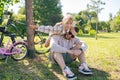 Laughing father and his daughter having fun together at the green park, relax and have fun together after cycling Royalty Free Stock Photo