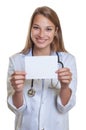 Laughing female doctor with blond hair showing card Royalty Free Stock Photo