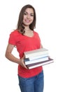 Laughing female student with long dark hair looking and books